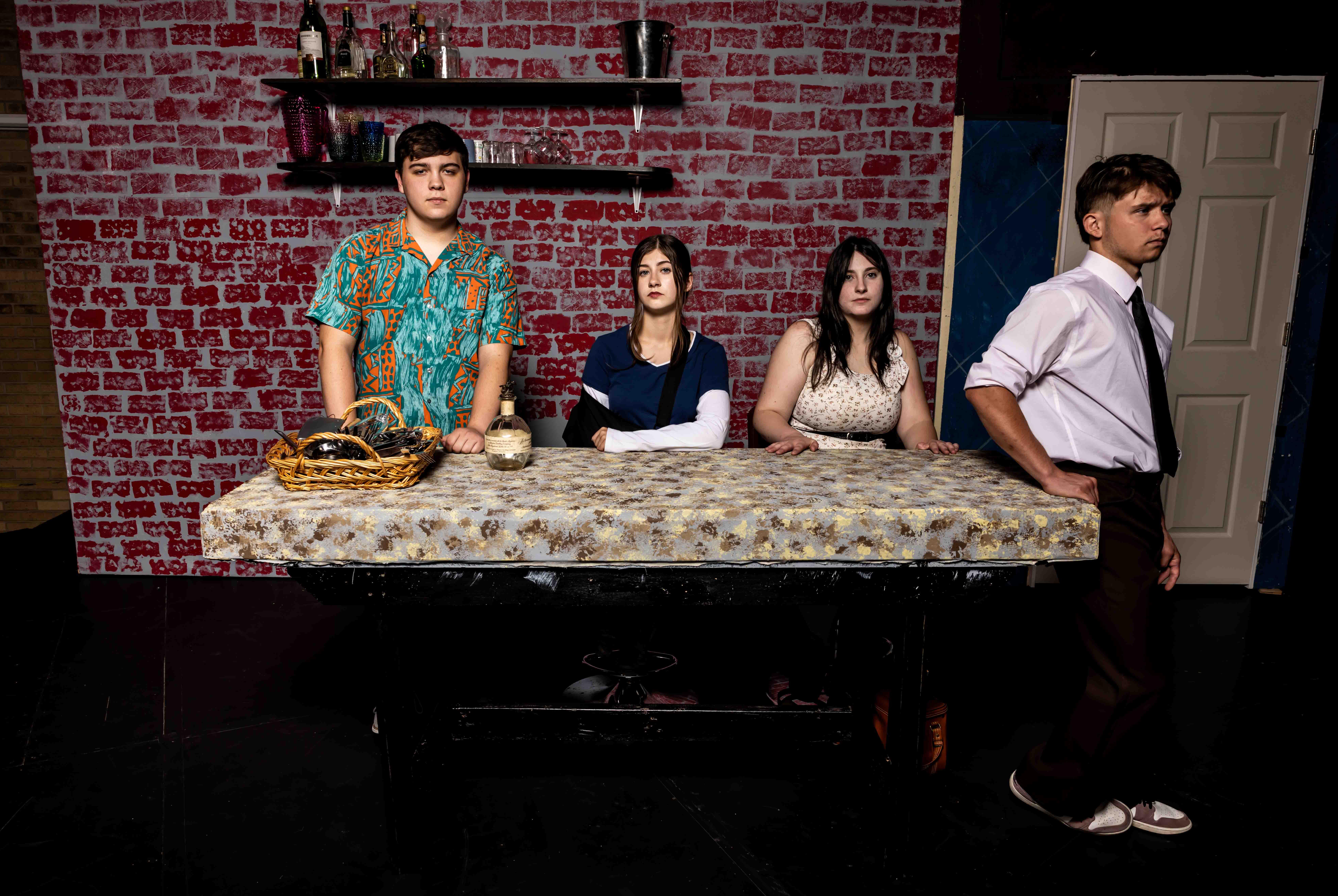 four young people standing at a bar with serious lookls on their faces