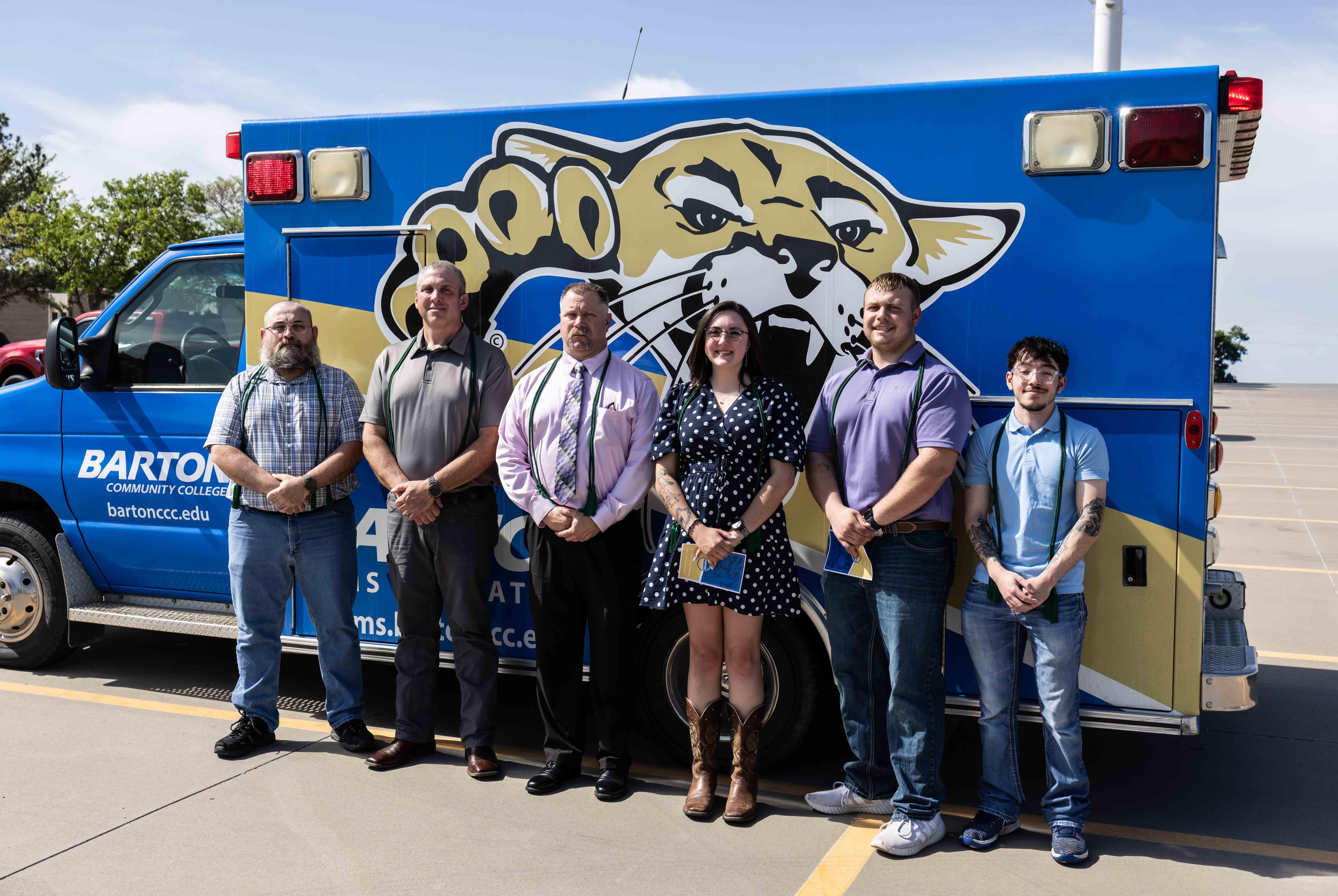 students standing in front of an ambulance with a cougar graphic on it