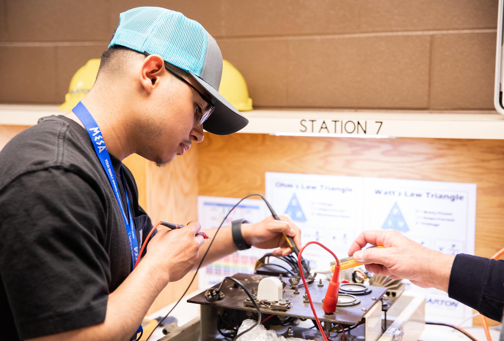 man uses electrical instrument to measure voltage