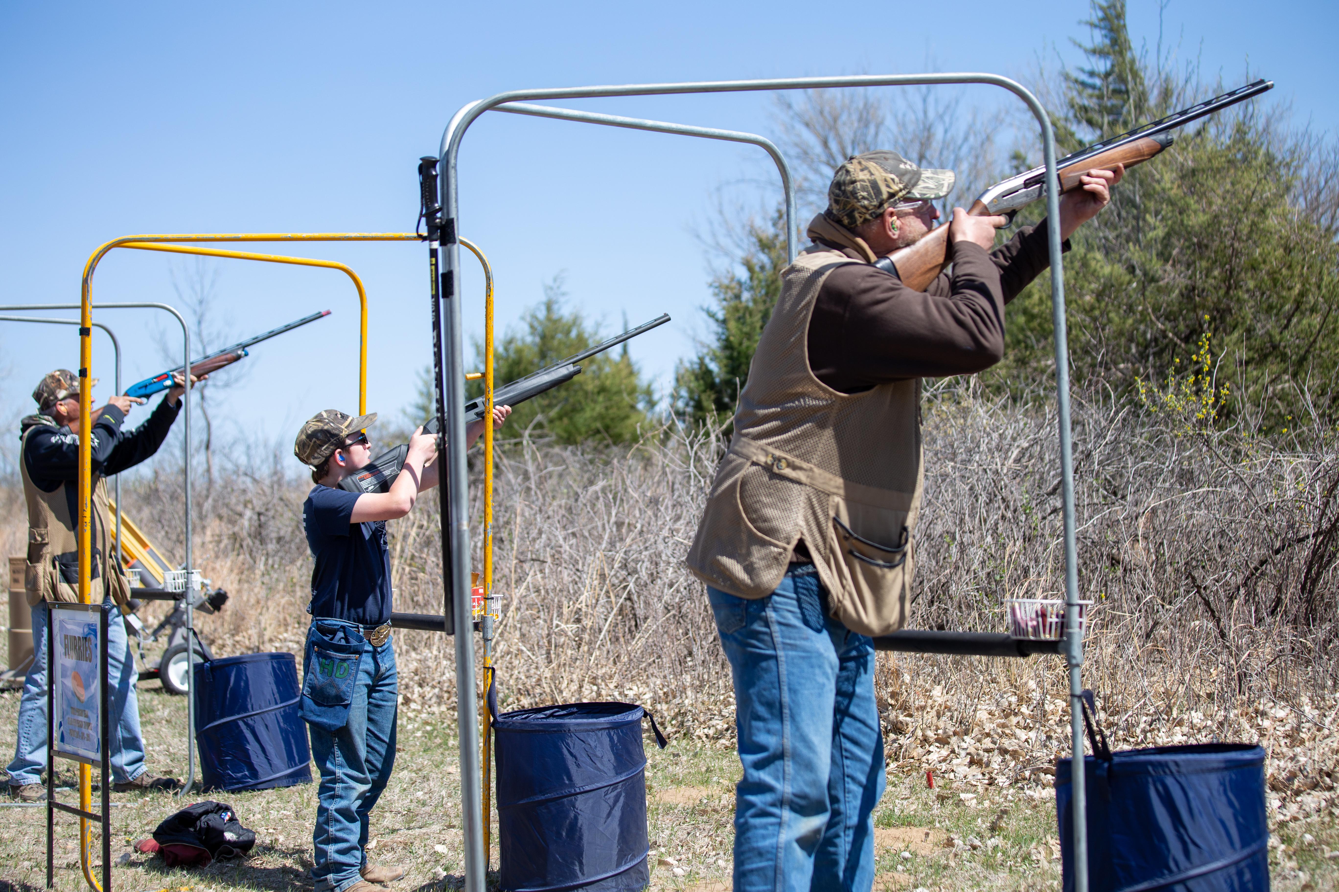 Participants at the 2023 clay shoot take aim at flying sporting clays down range.