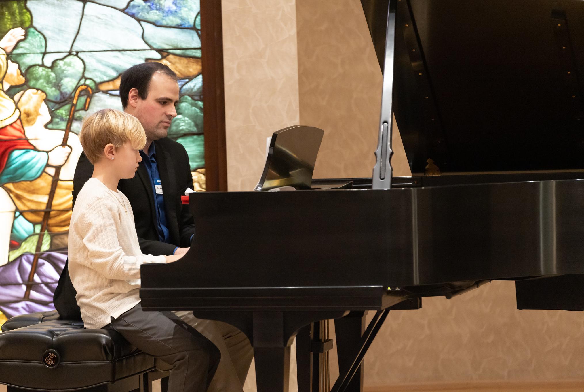 piano teacher playing a duet with a student