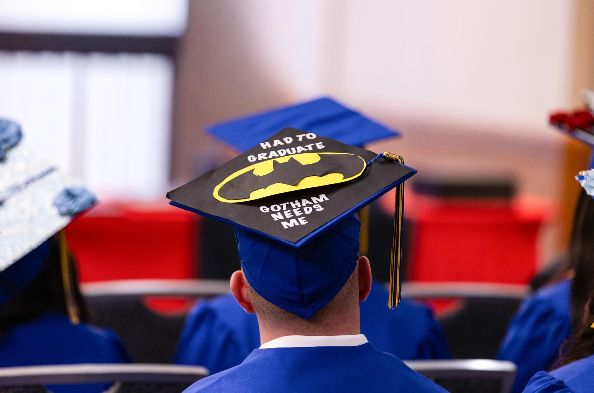 man with graduation cap on with batman logo on it