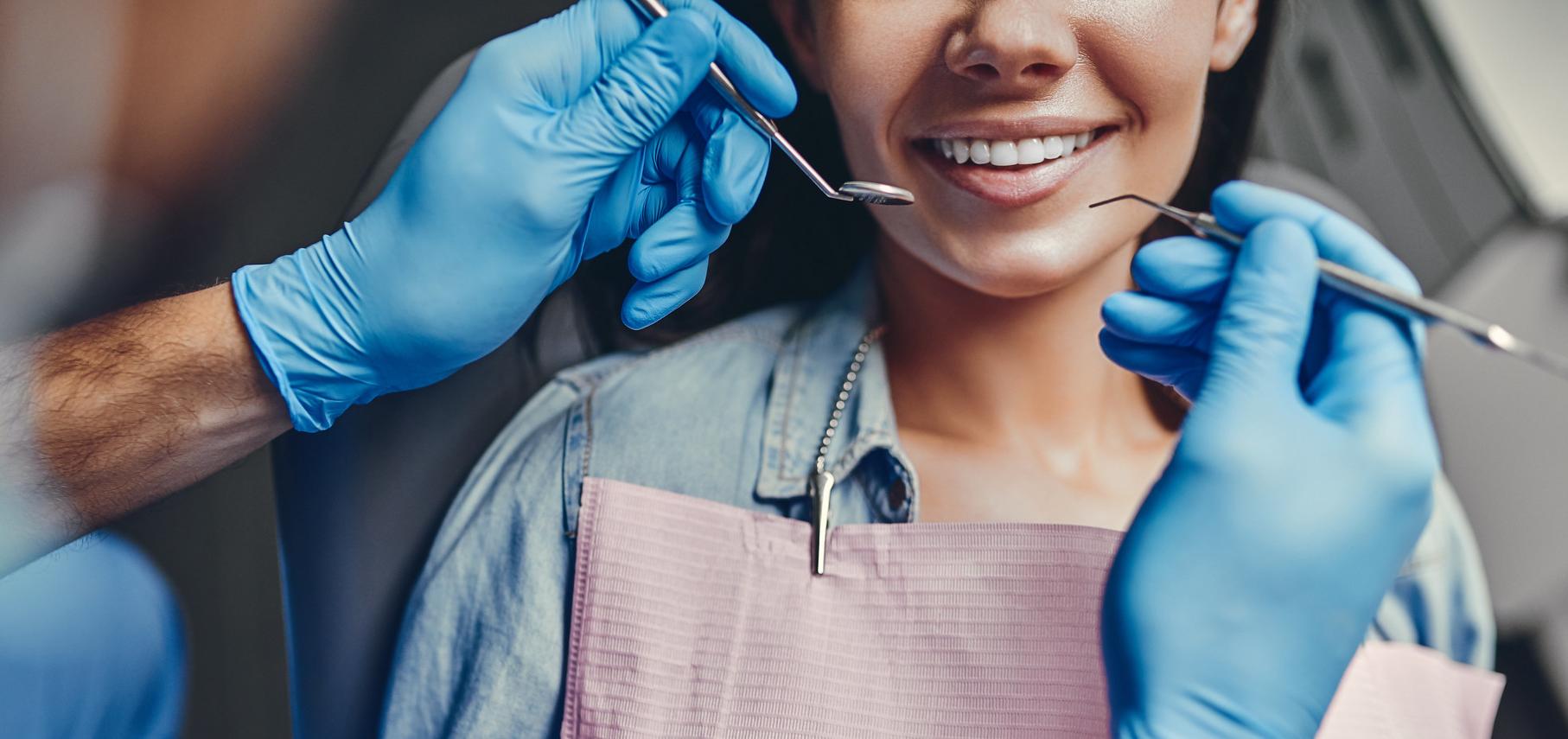 Dental hygienist cleans patient's teeth